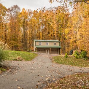 2-story Garage in the woods with Clay and Textured Evergreen ABM Panel